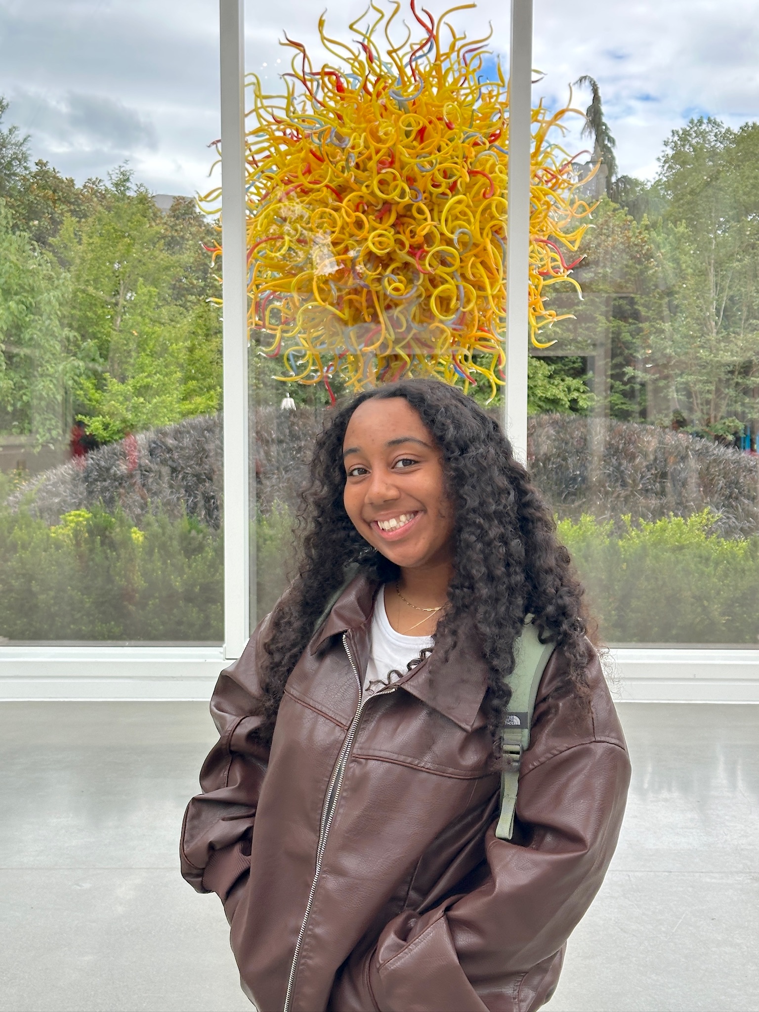 A picture of Jadan in front of a glass sculpture.